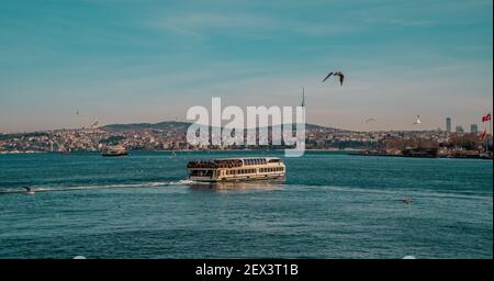 Istanbul, Turquie - 31 janvier 2021 - vue panoramique d'un ferry et de mouettes sur le Bosporus avec le côté asiatique d'Istanbul en arrière-plan Banque D'Images