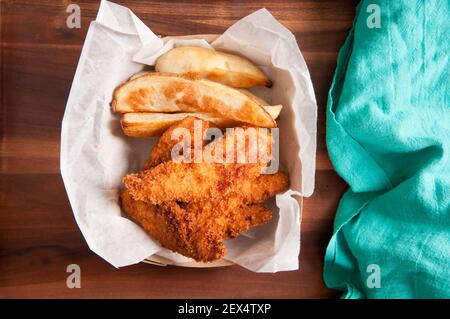 les doigts de poulet panés et les frites dans un récipient à emporter Banque D'Images