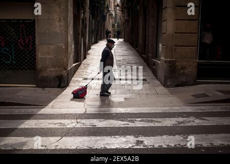 Un homme portant un masque passe devant une allée dans le quartier gothique de Barcelone. Malgré l'amélioration de la courbe des infections à coronavirus, l'Espagne se dirige vers une semaine de Pâques avec un verrouillage régional sur la majorité de ses territoires. Banque D'Images