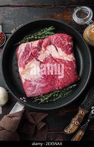 Ensemble de bœuf au veau brut, sur fond de table en bois foncé, avec vue sur le dessus Banque D'Images