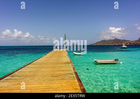 Vue sur la jetée des Caraïbes avec Turquoise Océan des Caraïbes et Union Island: Casuarina Beach, Palm Island, Saint Vincent et les Grenadines. Banque D'Images