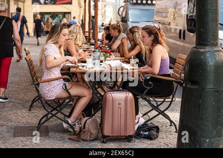 Prague - République tchèque - 08 01 2020: Deux jeunes filles attrayantes assises sur une terrasse ensoleillée en été