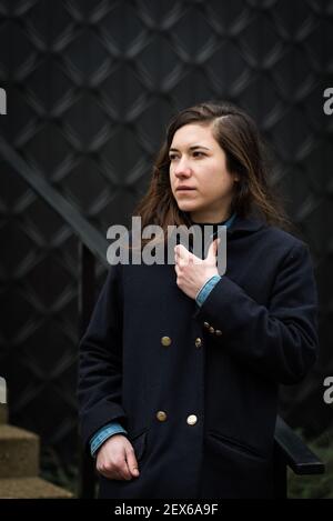 Molenbeek Port district, Bruxelles - Belgique - 01 04 2020: Belle fille de 27 ans à poil brun posant devant un magasin de Citroën DS Banque D'Images