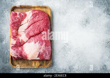 Ensemble de bœuf au veau brut, sur fond de pierre grise, plan plat avec vue de dessus, avec espace pour le texte Banque D'Images