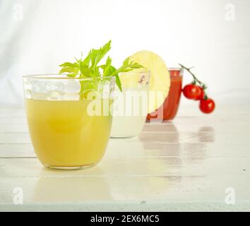 Trois verres avec 3 jus différents : tomate, ananas et céleri Banque D'Images