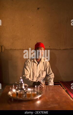 Maroc, Merzouga, portrait d'un serveur de thé, lumière de fenêtre éclairant un homme servant du thé Banque D'Images