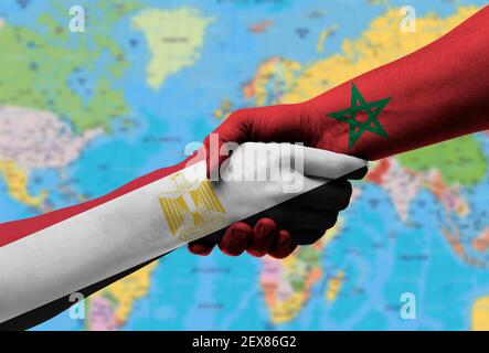 Poignée de main entre l'égypte et le maroc drapeaux peints sur les mains, illustration avec un chemin de coupure. Banque D'Images