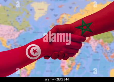 Poignée de main entre le maroc et la Tunisie drapeaux peints sur les mains, illustration avec chemin de coupure. Banque D'Images