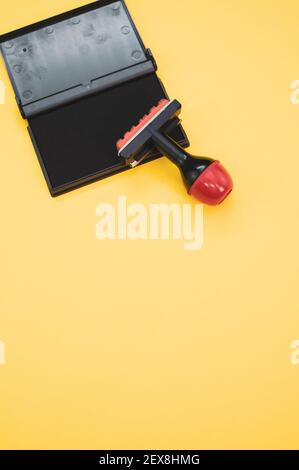 Tampon d'encre noire avec tampon en caoutchouc isolé arrière-plan jaune Banque D'Images
