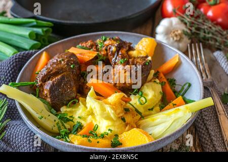 Viande avec pommes de terre et légumes sur une assiette Banque D'Images