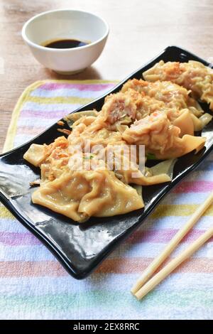 boulettes bouillies ou gyoza farcies écrasées de porc et de crevettes avec garniture de légumes frit, hacher l'ail sur une assiette en trempant le soja doux sauce Banque D'Images