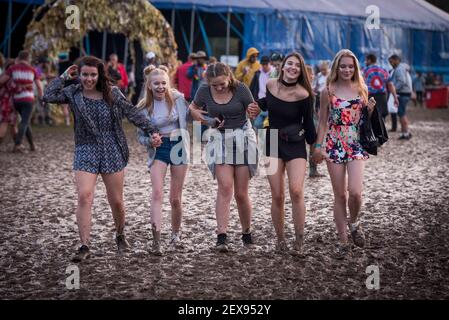 Festival des goers marchant dans la boue le jour 3 du festival 2016, Robin Hill Country Park sur l'île de Wight.photo Date: Samedi 10 septembre 2016. Le crédit photo devrait se lire: David Jensen Banque D'Images