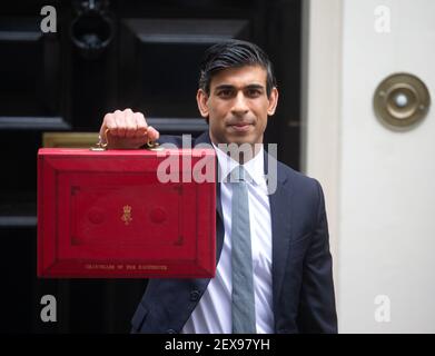 Le chancelier de l'Échiquier, Rishi Sunak, tient la fameuse valise rouge de Gladstone, avant de se rendre au Parlement pour lui remettre son budget. Banque D'Images