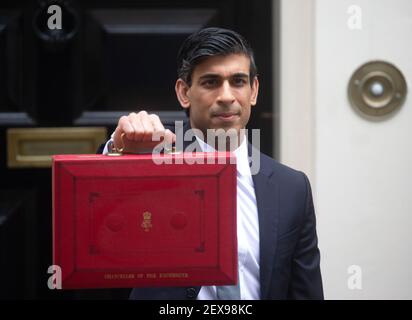 Le chancelier de l'Échiquier, Rishi Sunak, tient la fameuse valise rouge de Gladstone, avant de se rendre au Parlement pour lui remettre son budget. Banque D'Images