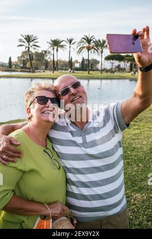 Un couple à la retraite prend un selfie avec dans un parc Banque D'Images