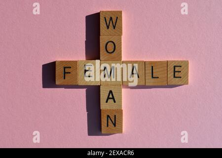 Femme, Femme, mots en lettres de l'alphabet en bois en forme de mots croisés isolés sur fond rose Banque D'Images