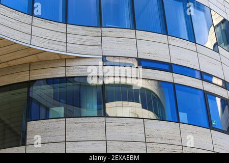 Düsseldorf (Köln-Bogen), Allemagne - 1er mars. 2021: vue rapprochée sur la façade incurvée isolée d'un bâtiment d'architecture moderne avec reflets de fenêtres en verre Banque D'Images