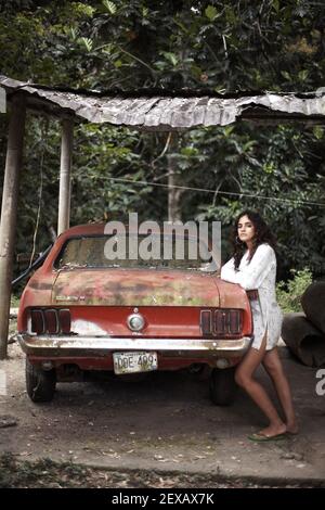 une femme avec mustang rouge couverte de poussière est assise dans une grange de fermiers attendant d'être remis à neuf dans sa gloire d'origine. Banque D'Images