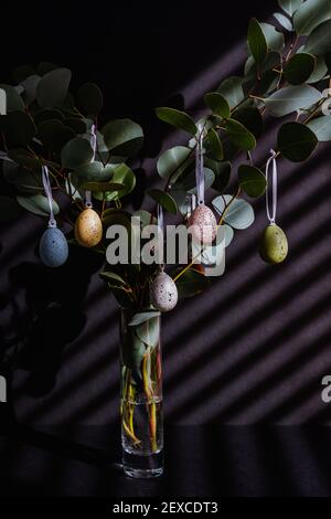 Branches d'eucalyptus décorées d'œufs de Pâques dans un vase Banque D'Images