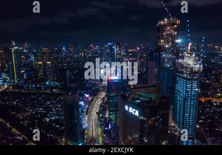 Vue aérienne nocturne des gratte-ciel en construction et du centre-ville moderne avec autoroute à plusieurs voies à Jakarta, Indonésie Banque D'Images