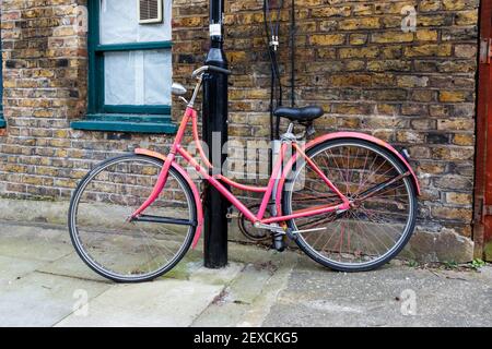 Une ancienne bicyclette peinte en rose enchaînée à un lampadaire à Islington, Londres, Royaume-Uni Banque D'Images