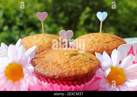 détail de 3 muffins emballés pour être donnés comme cadeaux, il ya des coeurs et des fleurs Banque D'Images