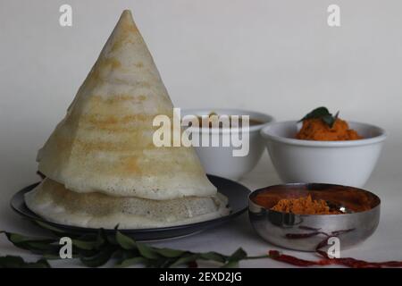 Dosa de ghee fin et croustillante avec sambar, chutney de noix de coco et Molaha Podi. DOSA est servi en forme de tente. Un petit déjeuner indien du Sud. Prise de vue sur fond blanc Banque D'Images