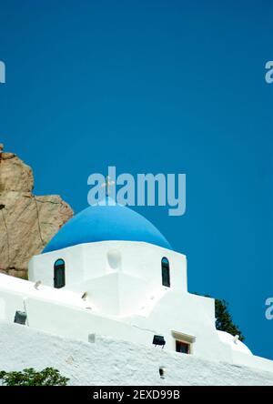 IOS, Grèce. Belle chapelle traditionnelle sur une colline au-dessus du vieux village des îles. Vue verticale avec ciel bleu clair pour l'espace de copie. Vue détaillée o Banque D'Images