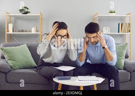 Jeune couple choqué regardant l'avis de changement de paiement hypothécaire ou des factures d'électricité énormes Banque D'Images