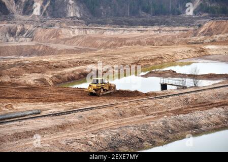 La lame a récupéré le paysage autour de la fosse ouverte. Processus de restauration des terres. Bulldozer lors de la remise en état de la mine une fois l'extraction du sable terminée. C Banque D'Images