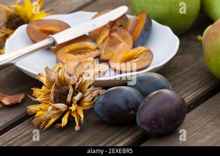 Prunes damson entières et coupées en deux Banque D'Images