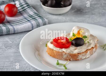 Bruschetta à la tomate, aux olives et à l'œuf de caille poché Banque D'Images