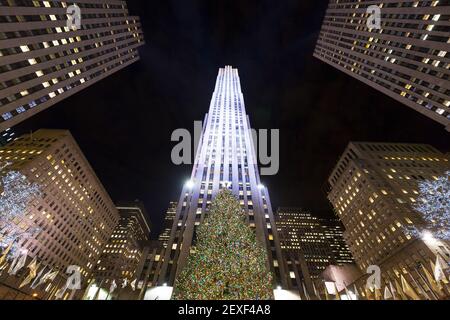 L'arbre de Noël brille au Rockefeller Center, au milieu du gratte-ciel Midtown Manhattan, dans la nuit à New York City NY USA. Banque D'Images