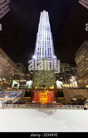 L'arbre de Noël brille au Rockefeller Center, au milieu du gratte-ciel Midtown Manhattan, dans la nuit à New York City NY USA. Banque D'Images