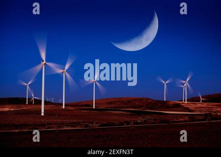 Éoliennes à vent tournant rapidement dans le vent avec la lumière de lune Banque D'Images