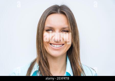 Portrait en gros plan de jeune femme d'affaires souriante et attrayante avec un sourire blanc parfait regardant l'appareil photo. Concept positif. Banque D'Images