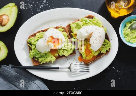 Toasts avec avocat et œufs servis sur l'assiette. Gros plan. Banque D'Images