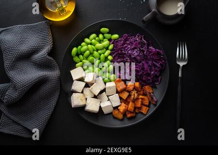 Bol végétalien appétissant savoureux avec tofu sur l'assiette. Vue de dessus Banque D'Images