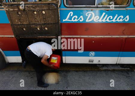 Caracas, Venezuela. 04e mars 2021. Le conducteur d'un bus de transport public remplit un peu de carburant avec un canister pour se rendre à la station-service. En raison de la pénurie de carburant, les camions font la queue pendant des heures devant les stations-service. L'essence est souvent en manque dans le pays qui possède les plus grandes réserves de pétrole au monde. À la fin de 2020, plusieurs chargements de carburant par camion-citerne avaient été livrés au Venezuela depuis l'Iran. Credit: Jesus Vargas/dpa/Alamy Live News Banque D'Images