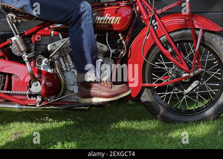 Gros plan sur un motard vintage portant un Jean et des bottes rouges à motif ailes. Banque D'Images