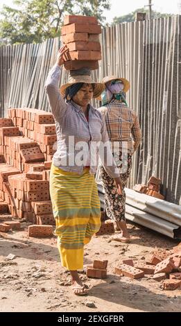 Des femmes portant des briques sur un site de construction à Mandalay, au Myanmar Banque D'Images