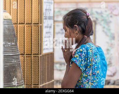 Femme priant dans le temple Moe Hnyin than Boaddai à Monywa, au Myanmar Banque D'Images