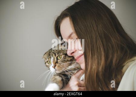 Young woman holding beau chat sur fond blanc Banque D'Images