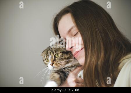 Young woman holding beau chat sur fond blanc Banque D'Images