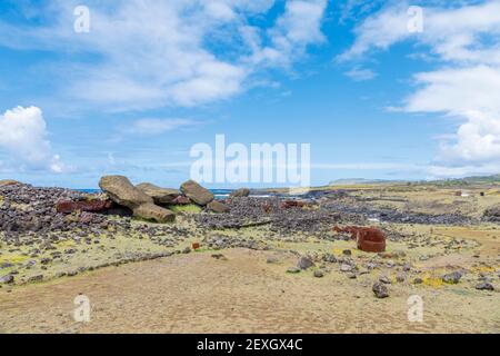 Moai renversés (statues) et pukao (nœuds hauts) à AHU Akahanga sur la côte sud rocheuse et sauvage de l'île de Pâques (Rapa Nui), au Chili Banque D'Images