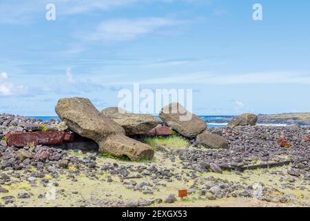 Moai renversés (statues) et pukao (nœuds hauts) à AHU Akahanga sur la côte sud rocheuse et sauvage de l'île de Pâques (Rapa Nui), au Chili Banque D'Images