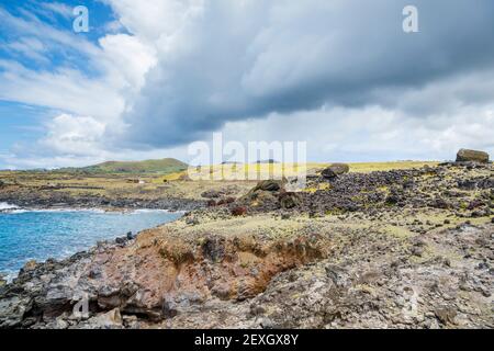 Moai renversés (statues) et pukao (nœuds hauts) à AHU Akahanga sur la côte sud rocheuse et sauvage de l'île de Pâques (Rapa Nui), au Chili Banque D'Images