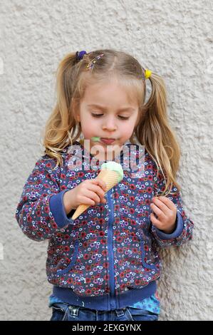 Cute little girl eating ice cream Banque D'Images