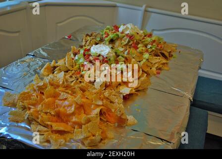 Table de cuisine Nacho table enveloppée de papier aluminium et couverte avec nachos Banque D'Images