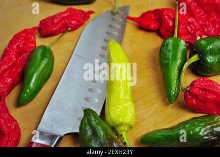 Poivre de banane jalapeno habanero frais et couteau sur un bois planche à découper Banque D'Images